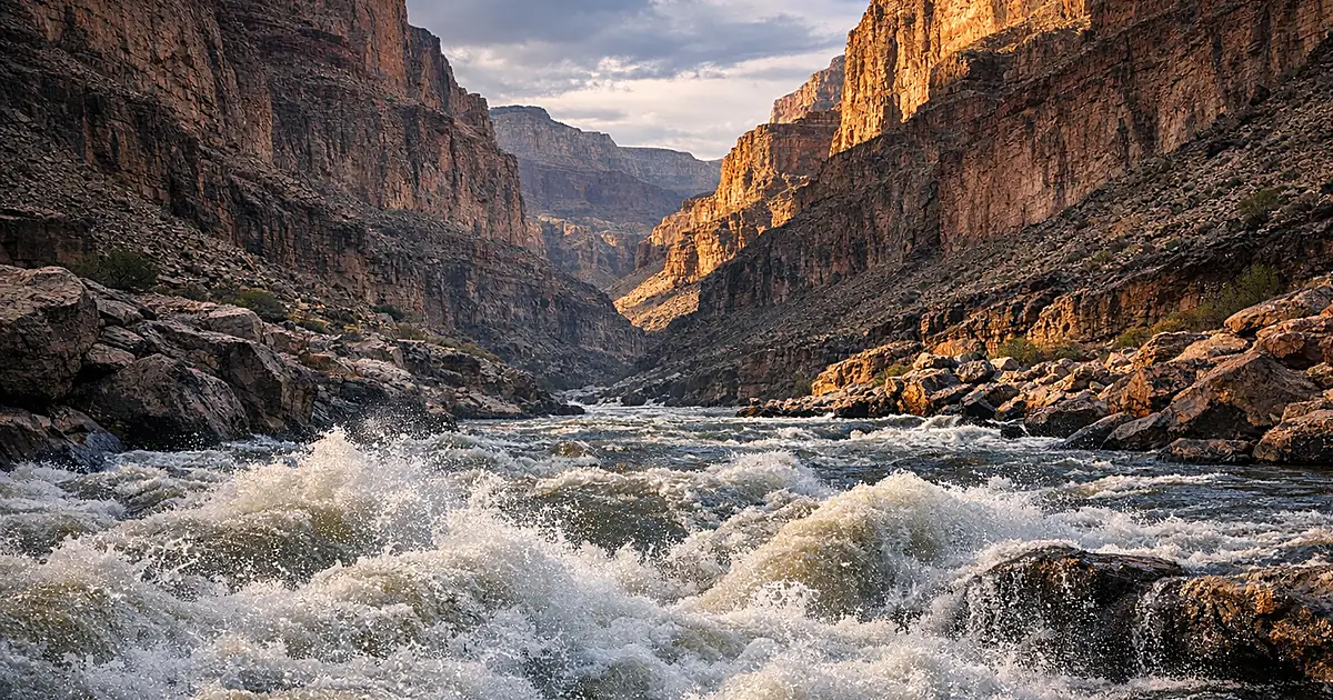 Colorado River rapids flowing through deep Grand Canyon with towering rock walls on both sides