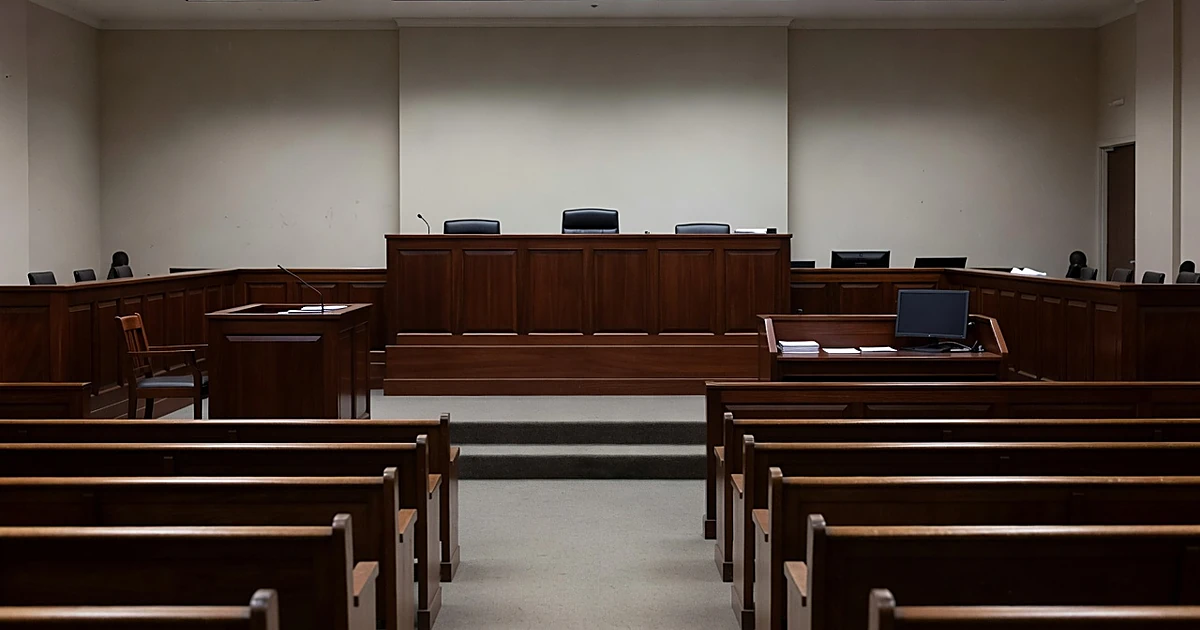 Empty federal courtroom interior showing judge's bench and gallery seating in neutral indoor lighting