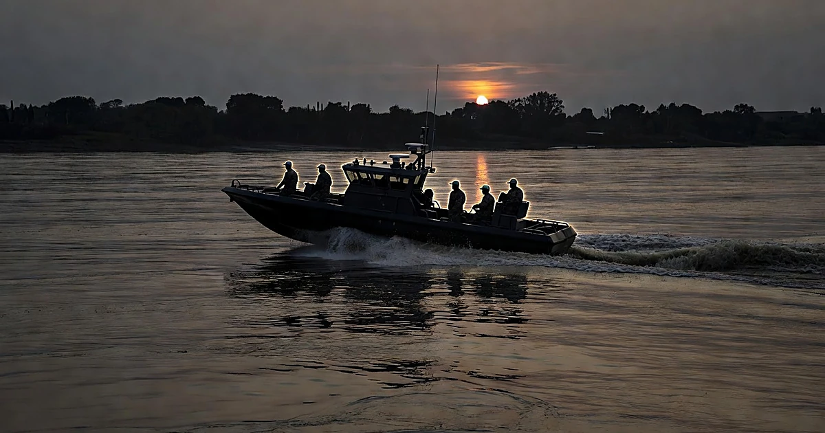 Coast Guard patrol boat navigating the Rio Grande at dusk with silhouetted crew members aboard