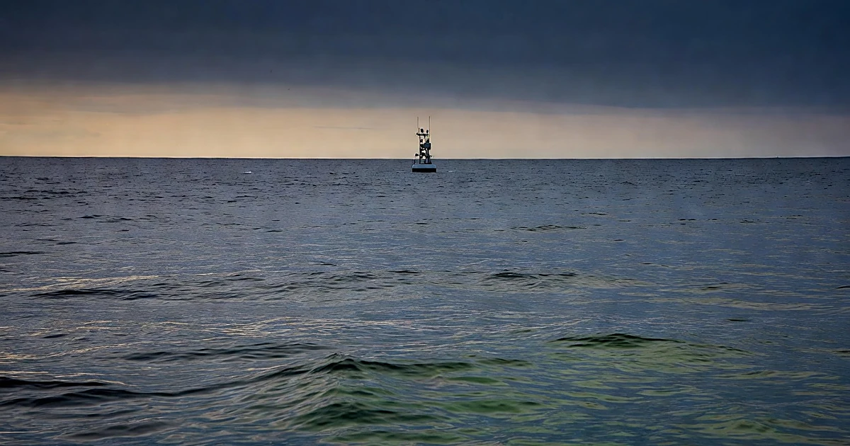 Research buoy floating on Pacific Ocean waters at dusk with thermal disturbances visible on surface