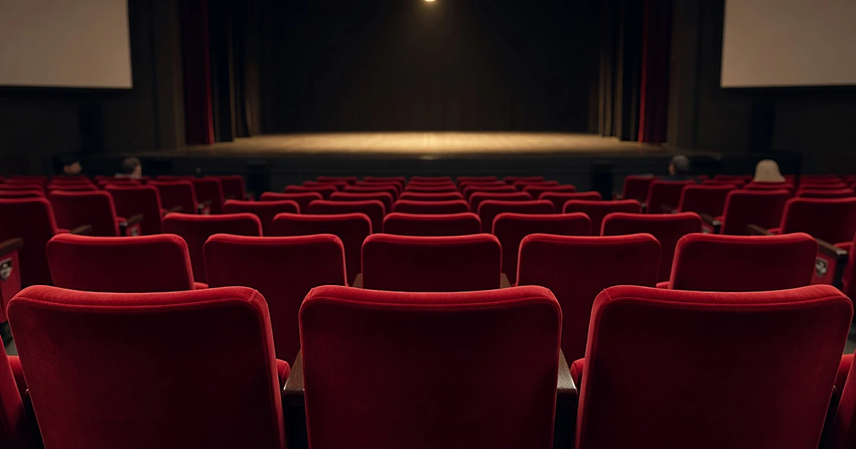 Empty front row theater seats in an intimate West End playhouse viewed from the aisle