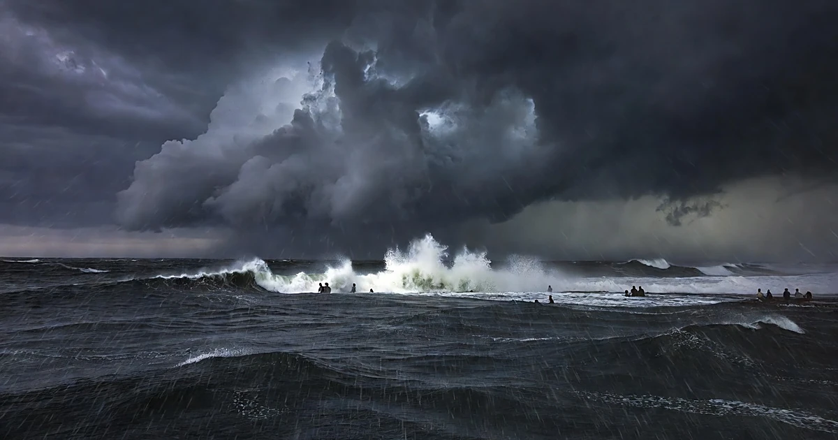 Dark storm clouds over turbulent Pacific Ocean with crashing waves and heavy rain during hurricane conditions