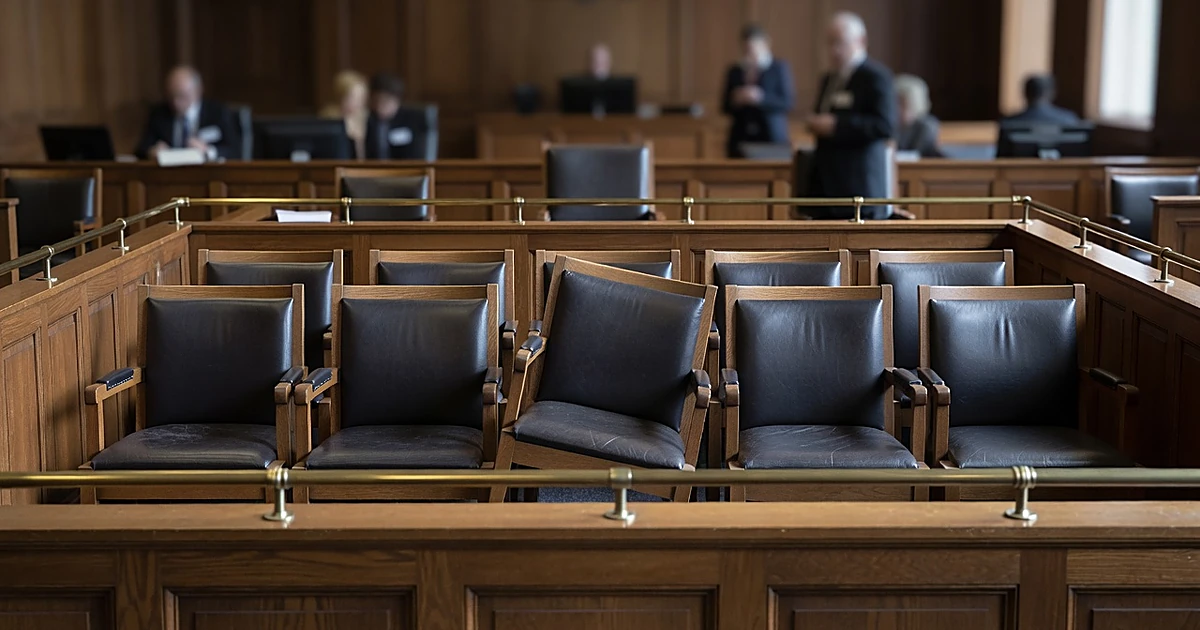 Empty jury box in courtroom with one chair positioned differently from the others