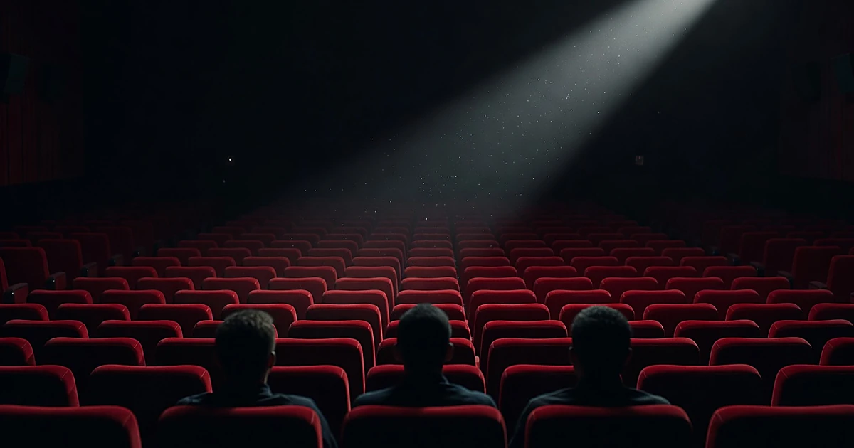 Movie theater interior with projection light beam cutting through darkness above silhouetted audience members