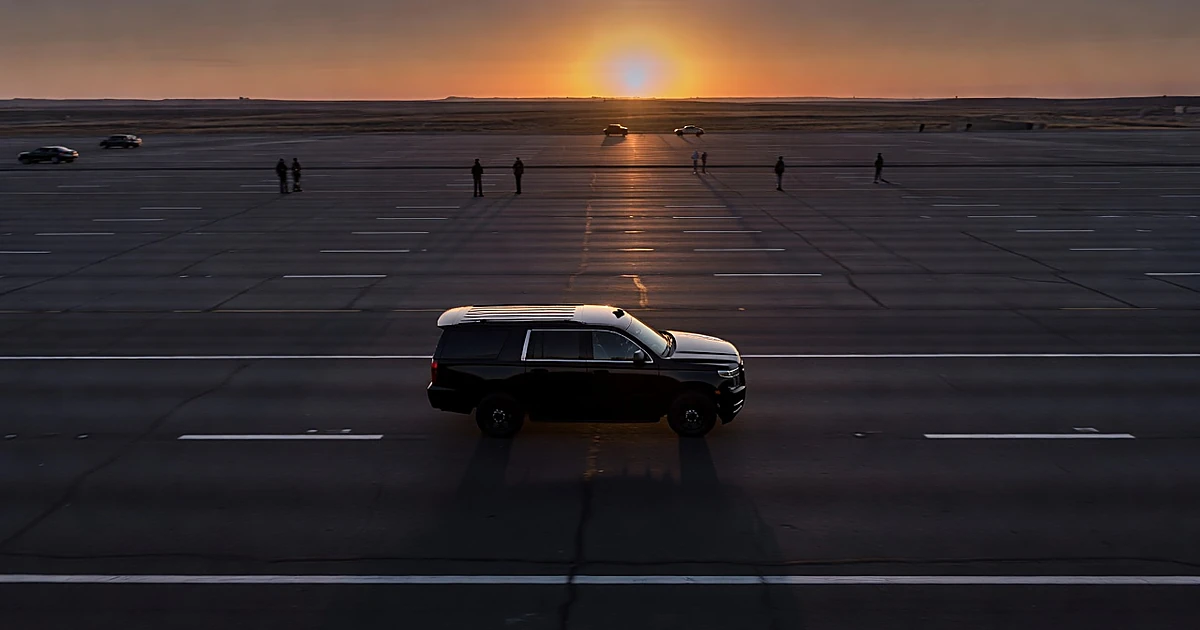 Presidential motorcade vehicle on empty highway at dusk with motion blur suggesting constant travel