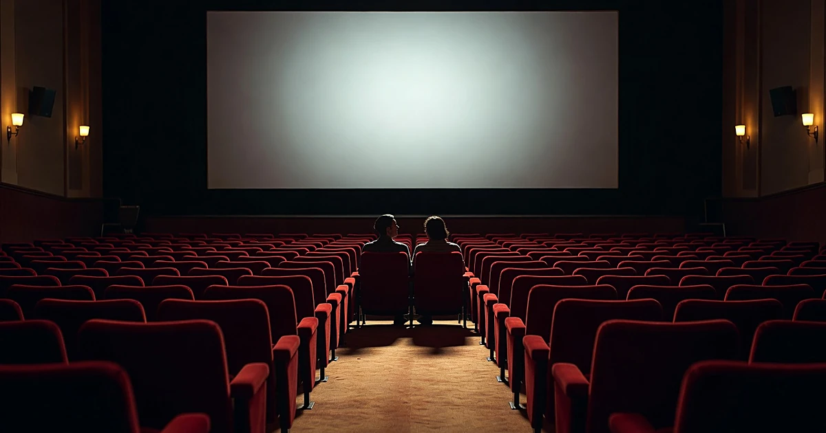 Two silhouetted figures seated together in an empty vintage movie theater with glowing screen ahead
